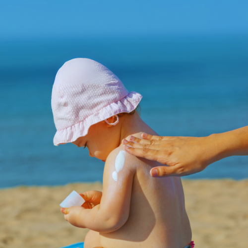 Niemowlak smarowany kremem z filtrem